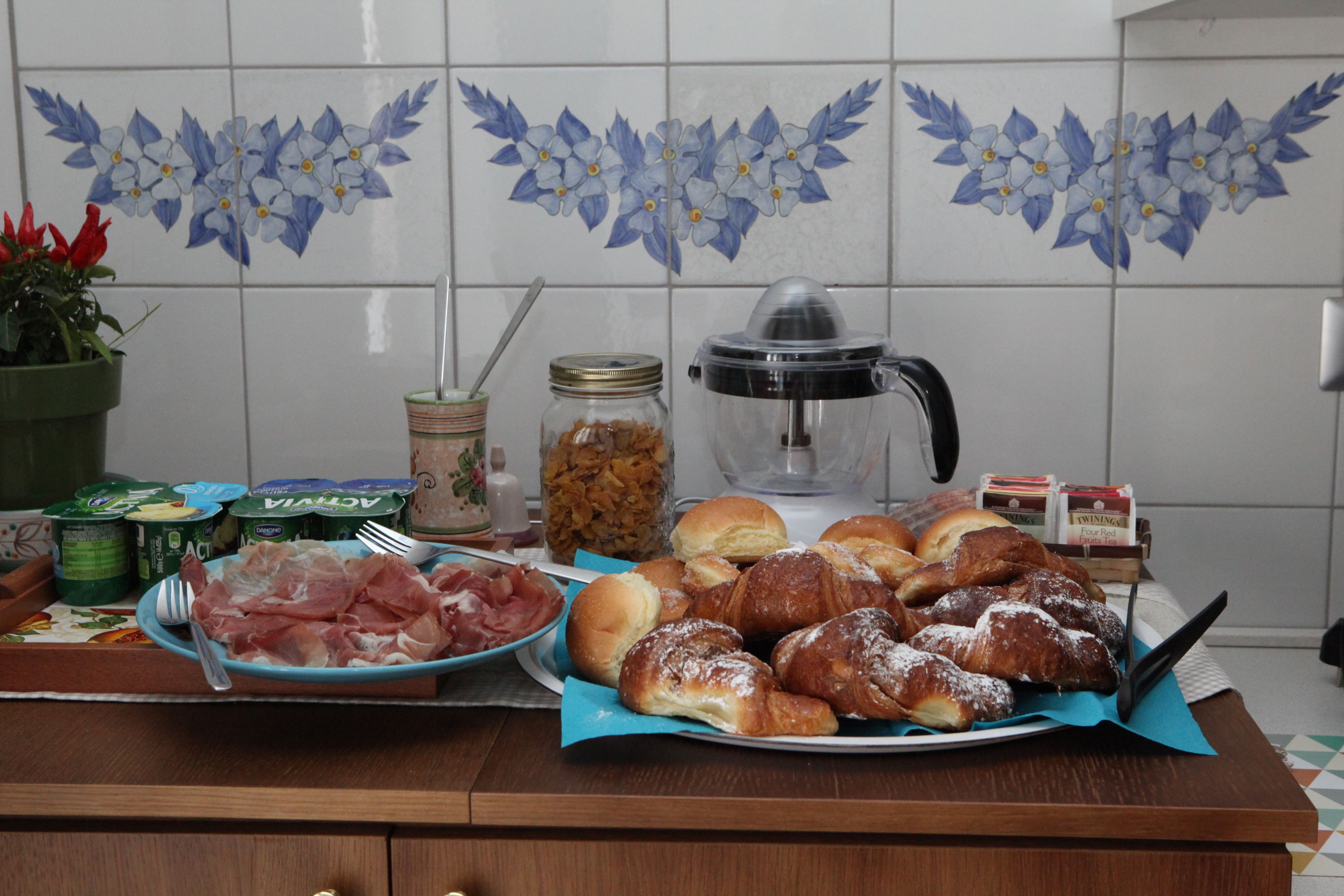 A kitchen counter with food items, a coffee maker, and a decorative tile backsplash.