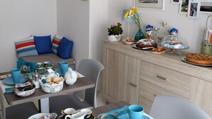 Un coin repas avec une table mise pour le petit-déjeuner, comprenant des assiettes, des tasses et une variété d’aliments.