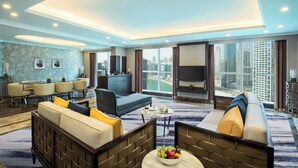 Habitació d'hotel moderna amb sofà, butaca i zona de menjador.