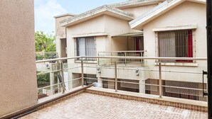 A residential building with a tiled balcony and metal railings. - GuestHouser 5 BHK Bungalow 6931 (Mawal)