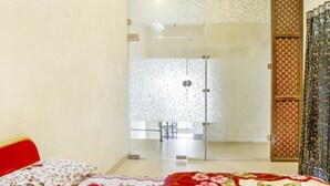 A room with a bed, a glass door leading to a bathroom, and a patterned curtain. - GuestHouser 5 BHK Bungalow 6931 (Mawal)