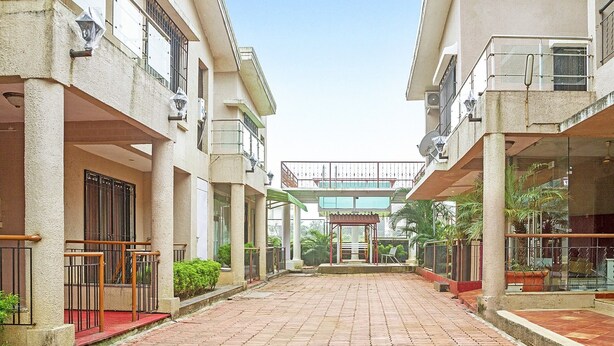 A corridor with a tiled floor leading to a building entrance. - GuestHouser 5 BHK Bungalow 6931 (Mawal)