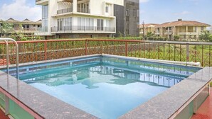 A rectangular pool with a metal railing, surrounded by a low wall and a paved area. - GuestHouser 5 BHK Bungalow 6931 (Mawal)