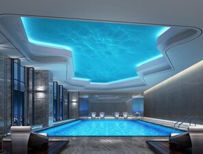 Una piscina techada, sillones reclinables de piscina