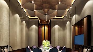A modern dining area with a central table, chairs, and a decorative ceiling.