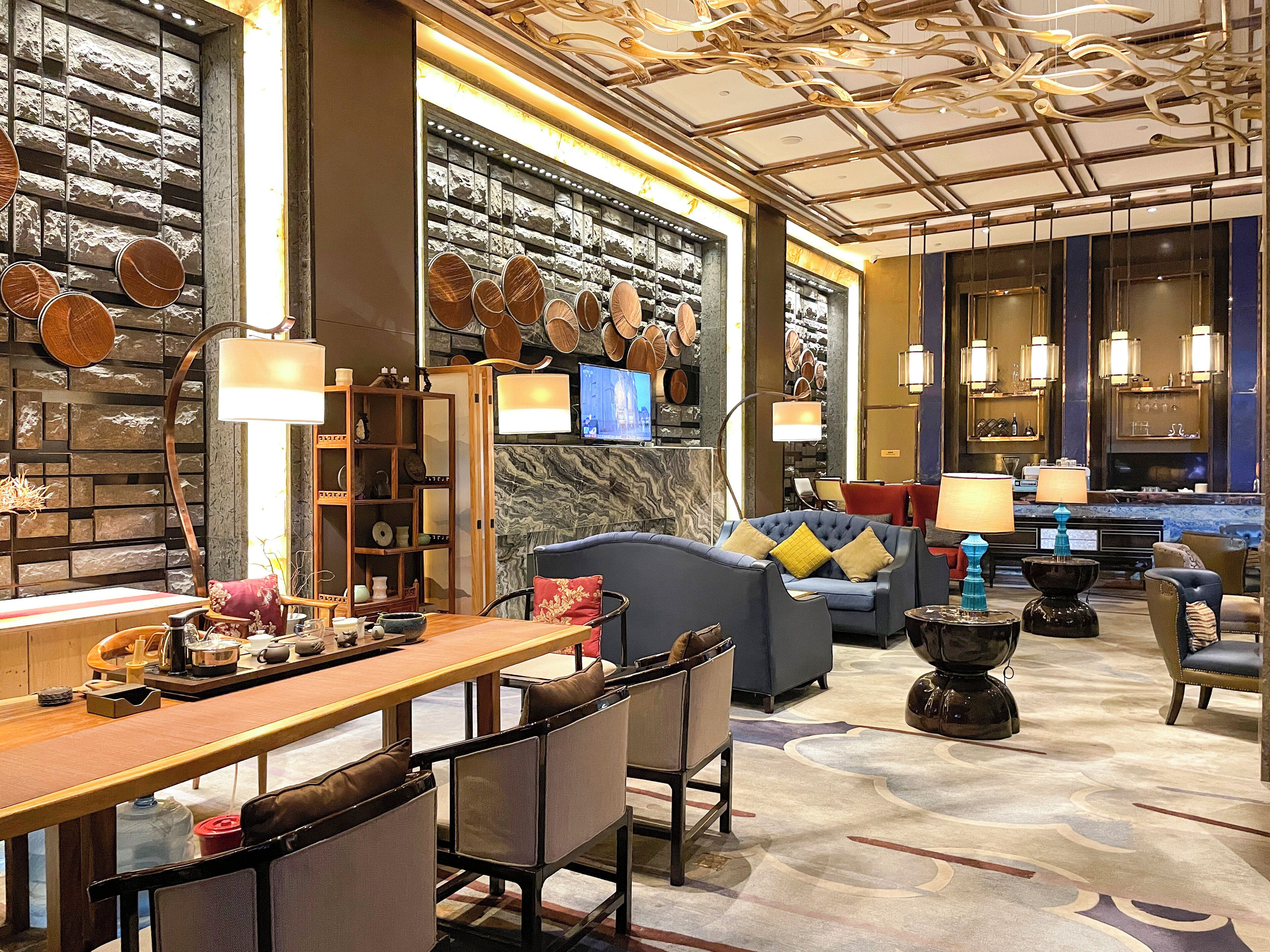 A modern interior with a bar area, seating, and a wall decorated with pottery.