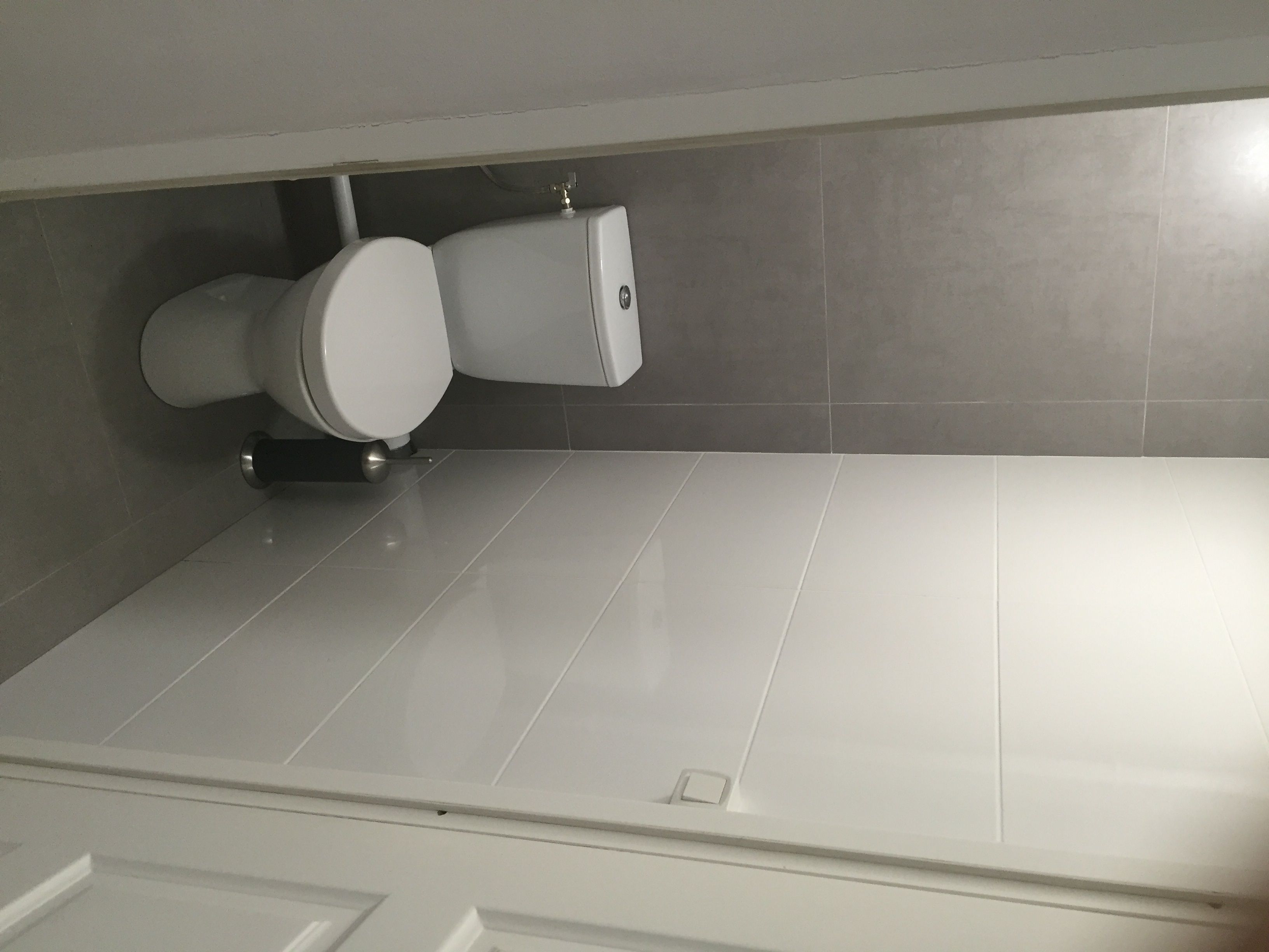 Ein Badezimmer mit Toilette, Bidet und einem weißen Fliesenboden.
