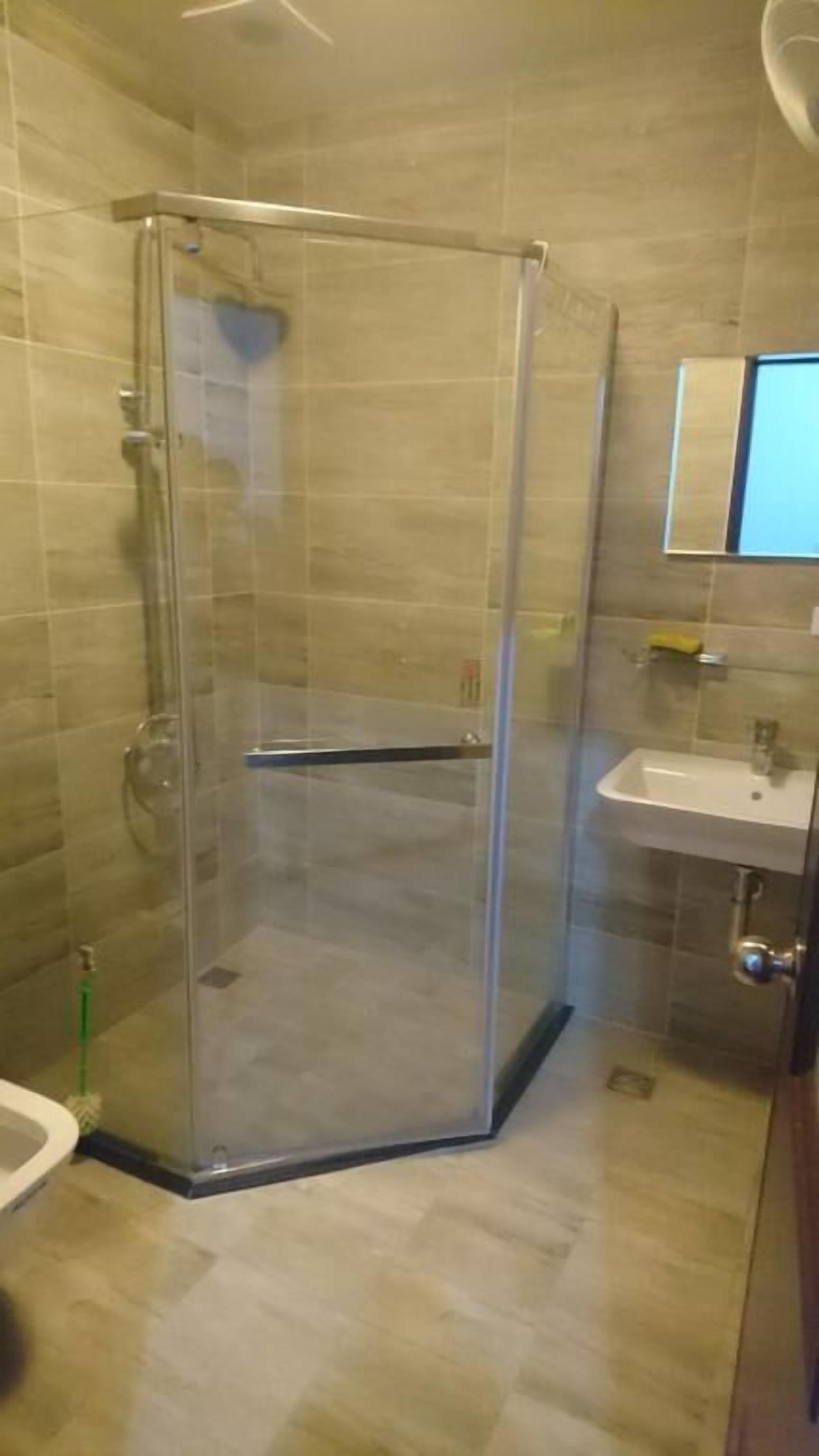 Ein Badezimmer mit Duschkabine, Waschbecken und Spiegel.