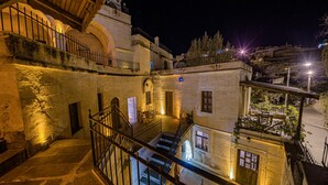 Un edificio storico con più livelli, pareti in pietra e una scala che conduce a un piano superiore.