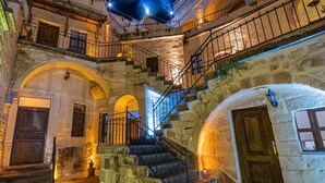 Un edificio storico dall'architettura in pietra, caratterizzato da una scalinata centrale, portali ad arco e balconi.