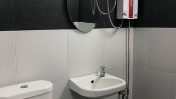 Un baño con inodoro, lavabo y ducha.