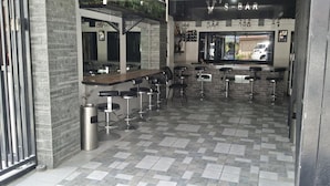 Zona de bar con mostrador y varios taburetes.