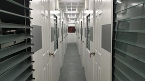 A corridor with doors on both sides, leading to rooms.