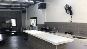 Una cocina moderna con una isla grande, un lavamanos integrado y una ventana con persianas.