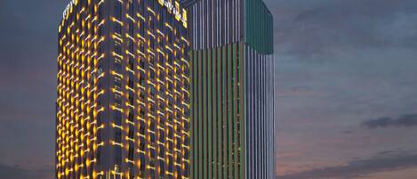 A modern high-rise building with illuminated patterns on its facade, likely a hotel or commercial property.