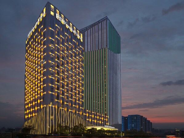 A modern high-rise building with illuminated patterns on its facade, likely a hotel or commercial property.