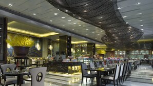 A spacious hotel lobby with a long reception desk, multiple seating areas, and a decorative ceiling. - Wanda Vista Nanning (Nanning)