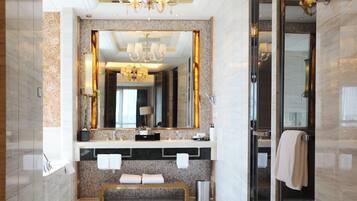 A modern bathroom with a large mirror, a bench, and a glass shower enclosure.