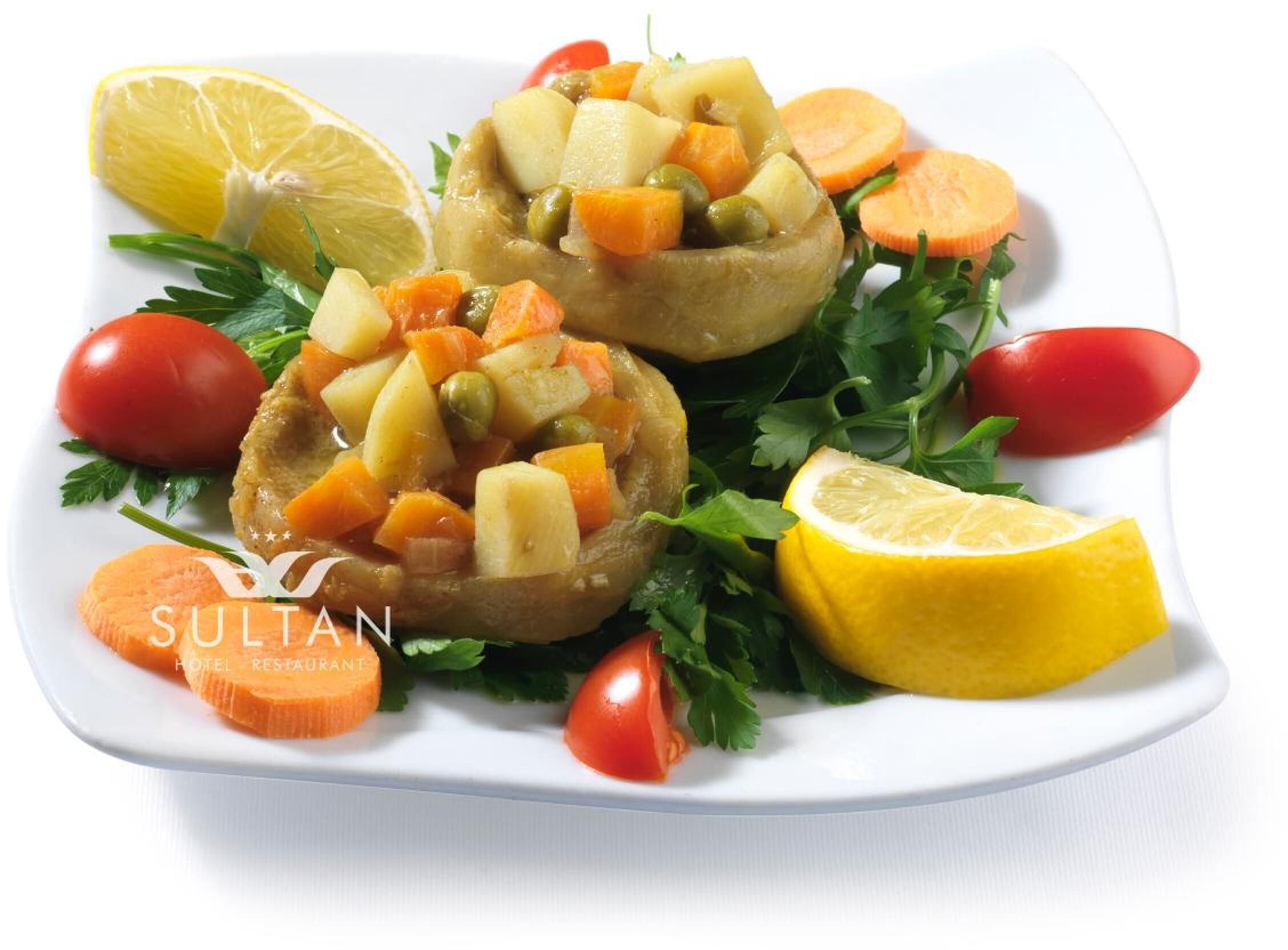 Stuffed bell peppers with a garnish of parsley, lemon slices, and cherry tomatoes on a white plate.