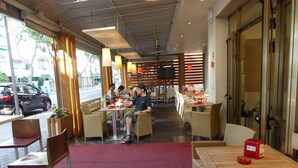 A cafe with outdoor seating, tables, and chairs. - Hotel Madison (Jesolo)