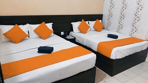 A hotel room with two beds, each with white bedding and orange accents, a dark headboard, and a nightstand with a phone and glasses. - Hotel Bharat Palace (Jaipur)