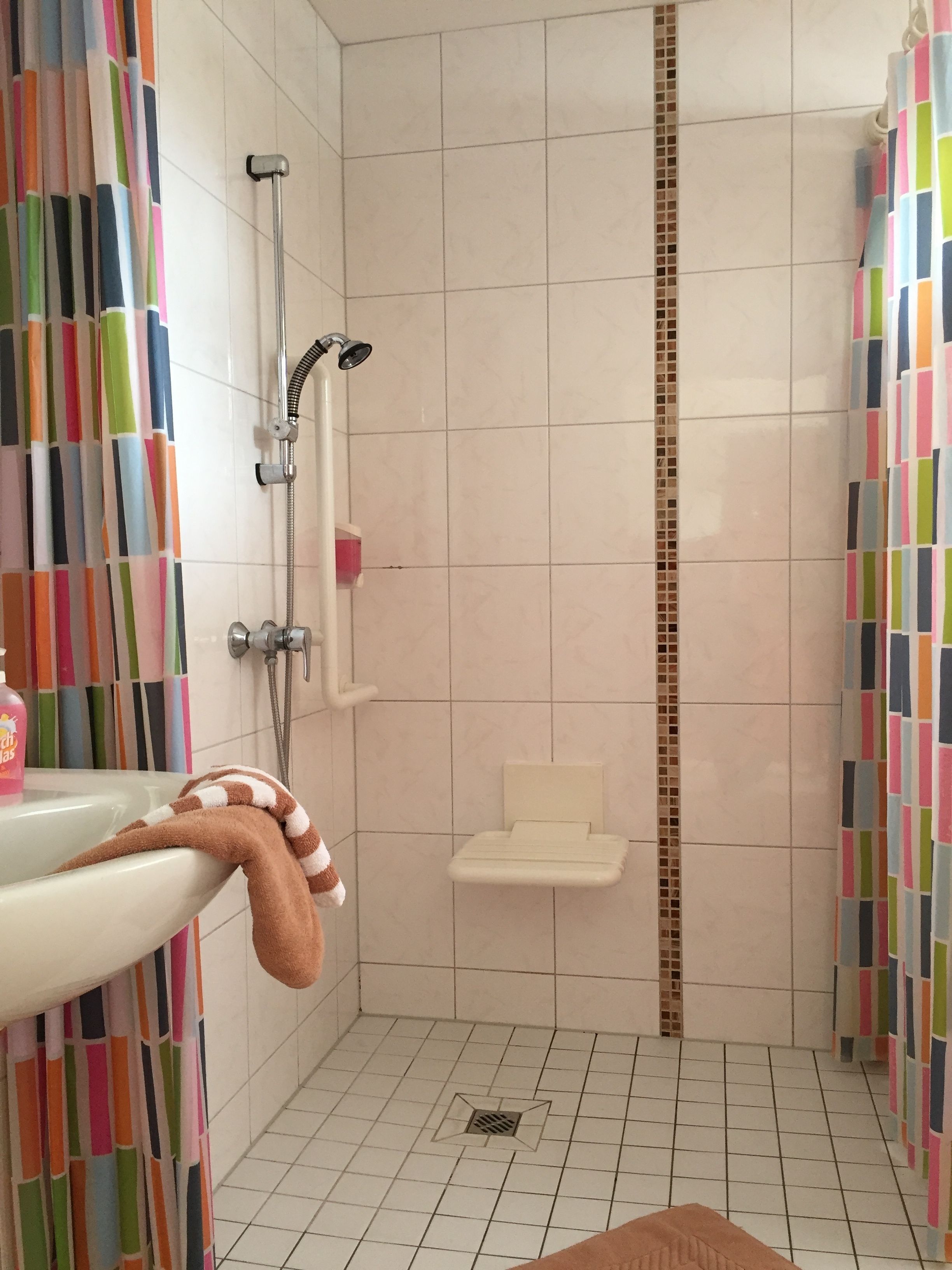Un baño con ducha, lavamanos e inodoro.