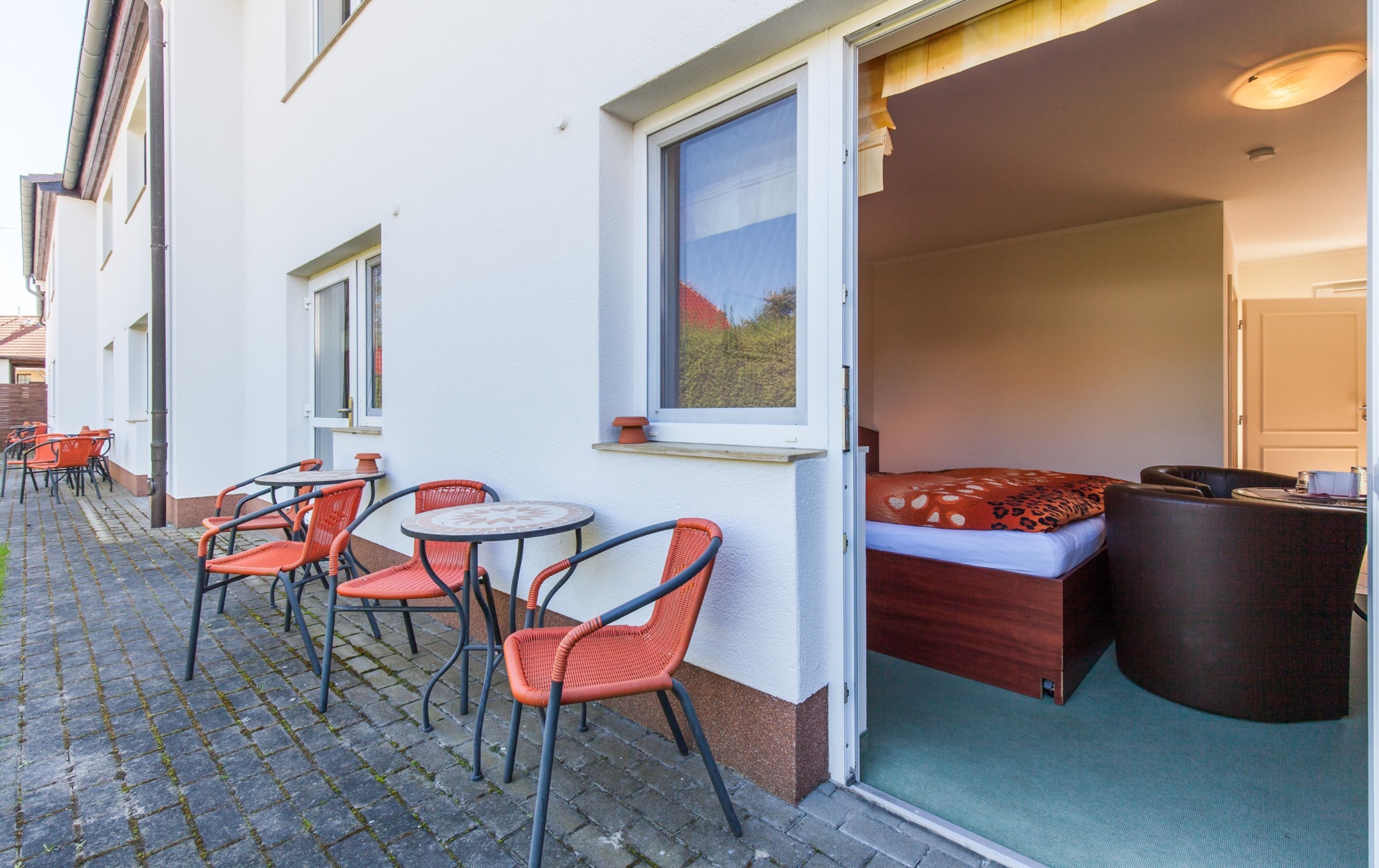 A hotel room with a bed, a small table, and two chairs.