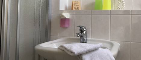 A bathroom with a sink, mirror, and towel rack.