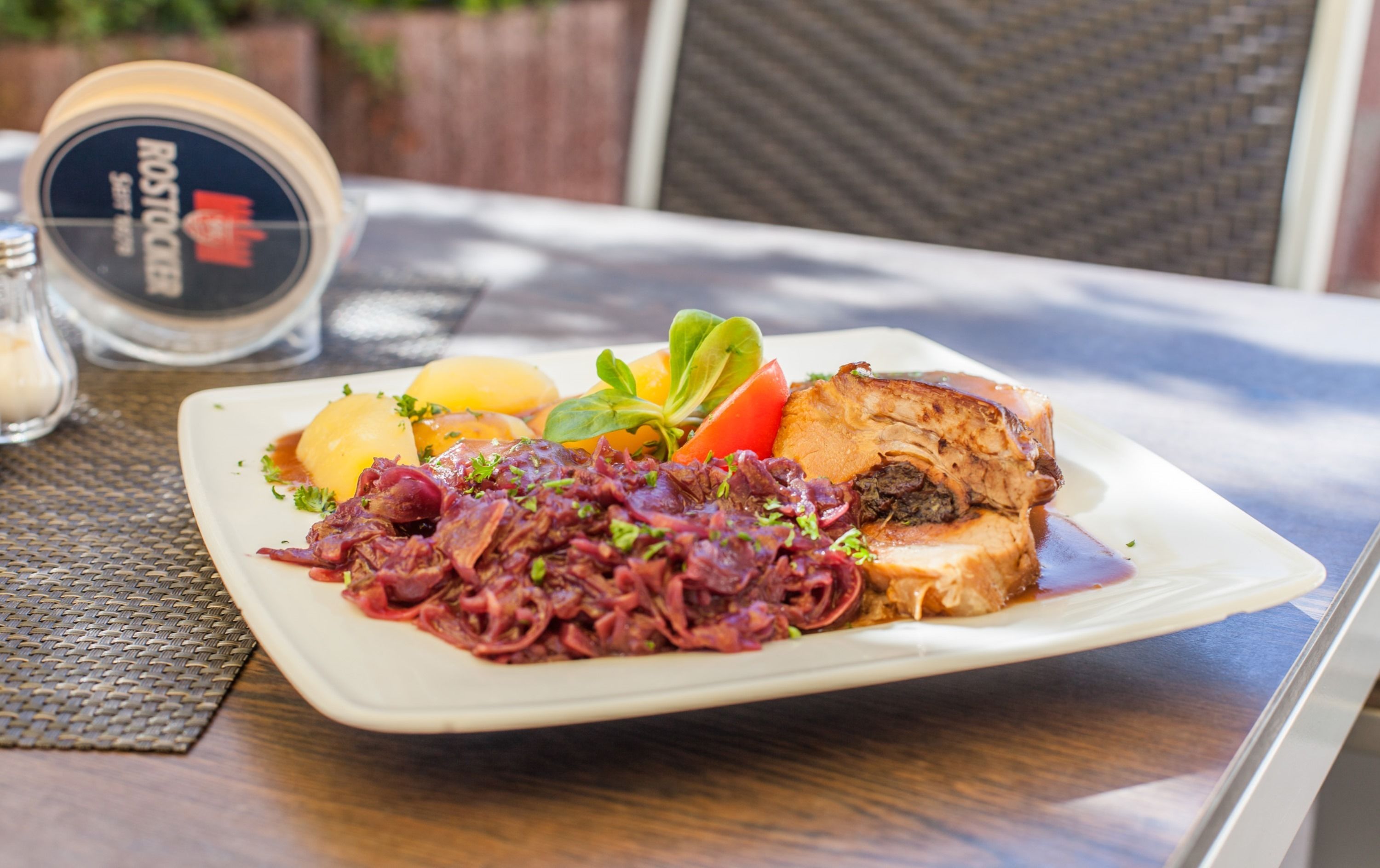 Une assiette de nourriture comprenant une variété de légumes et un morceau de viande, le tout servi dans une assiette blanche.