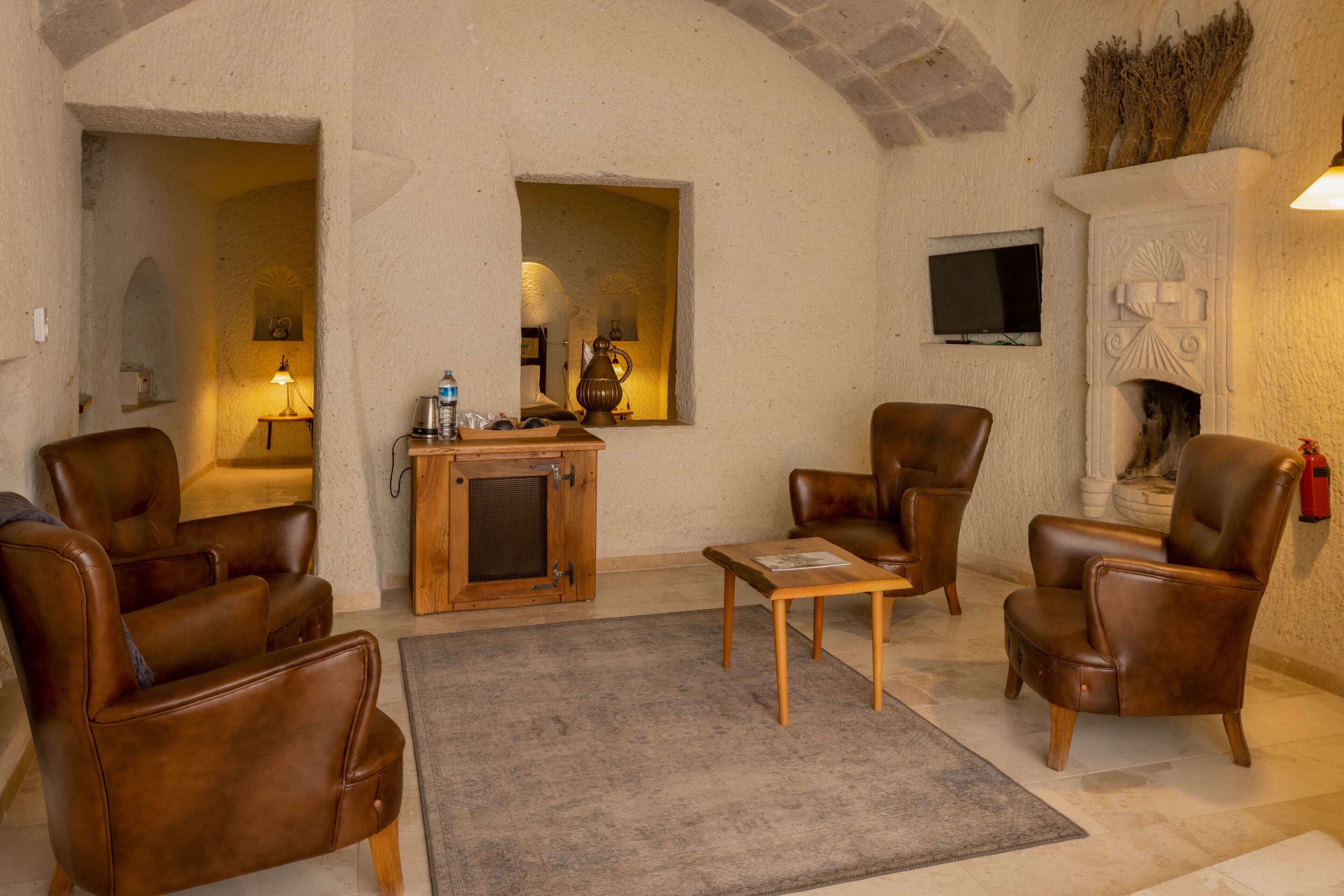Una sala de estar acogedora con sillones de cuero, una mesa de centro de madera y una chimenea.