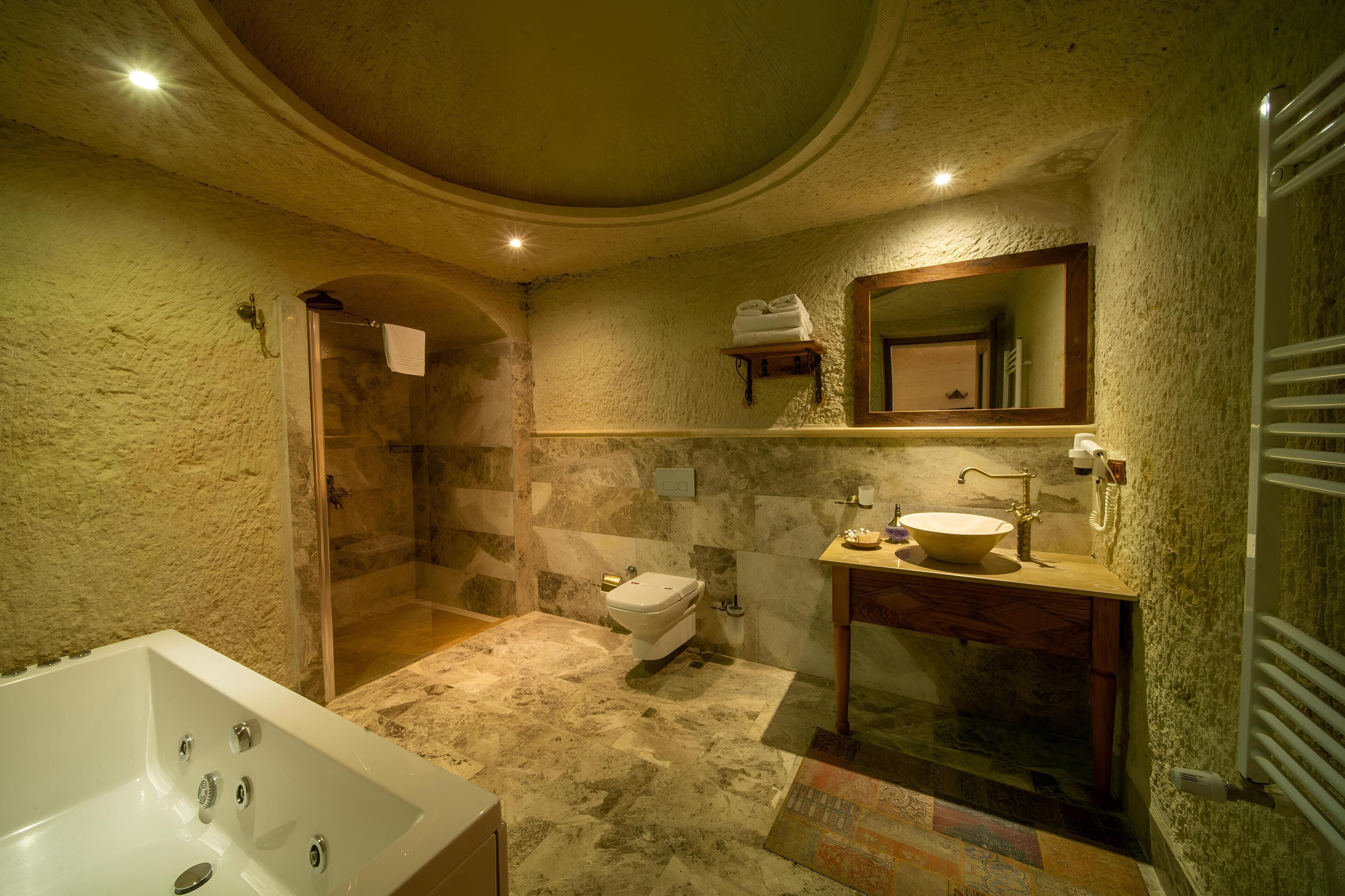 Een badkamer met een bad, toilet en douche.