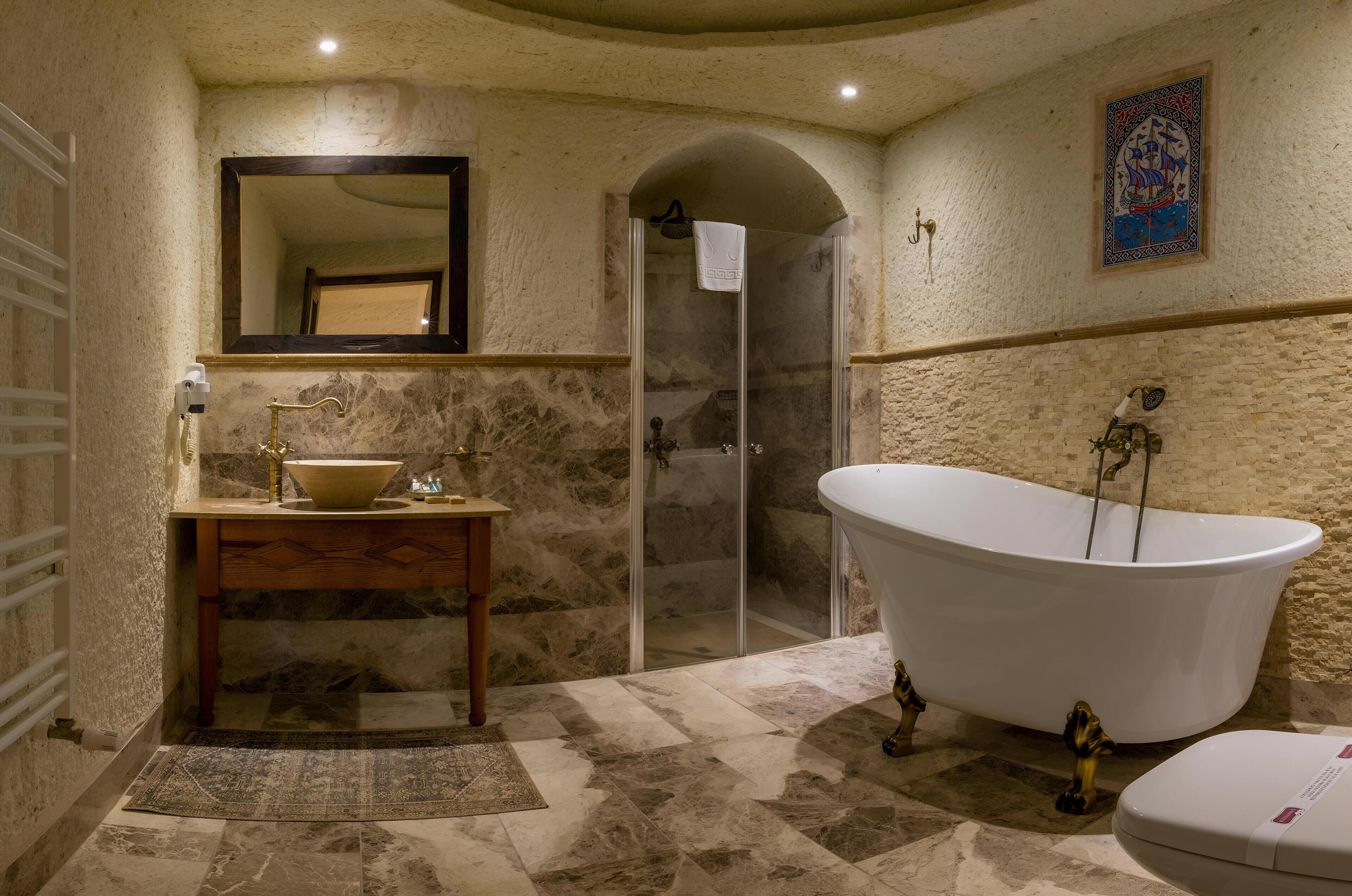 Ein Badezimmer mit freistehender Badewanne, einem Waschbecken mit Spiegel darüber und einer Duschkabine.