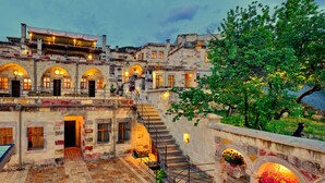 A historic building with a courtyard, stone staircase, and arched windows. - Seki Cave Hotel, Wake Up to Hot Air Balloons (Avanos)