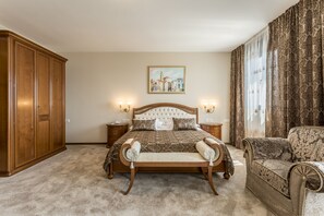 A bedroom with a large bed, a wooden wardrobe, a bench, and a chair. - Hotel Cvita (Split)