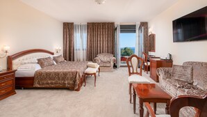 Une chambre d’hôtel avec un grand lit, un canapé, une table à manger et un téléviseur.