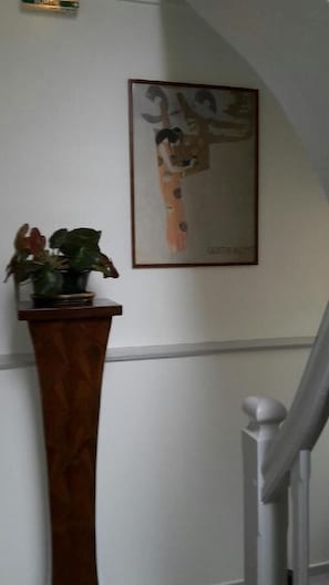 A staircase with a white railing, a wooden baseboard, and a framed artwork on the wall. - Hôtel Du Jura (Audincourt)