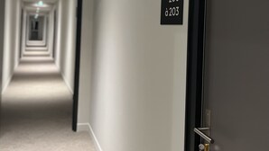 A hallway with directional signs indicating room numbers 204, 200, and 203. - Hôtel Le Ponson (Aubenas)