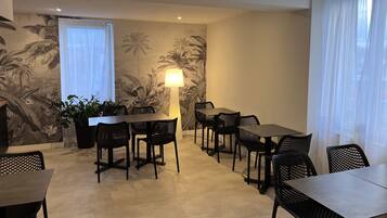 A dining area with a table and chairs, a floor lamp, and a wall with a tropical mural.