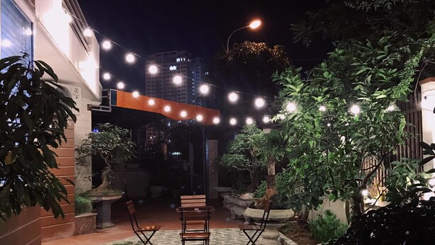 An outdoor patio area with string lights, two folding chairs, and a potted plant. - Sky Halong Hotel (Bai Chay)
