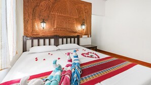 Ein Hotelzimmer mit einem großen Bett, einem Holzkopfbrett, zwei Wandleuchten und einem kleinen Nachttisch.