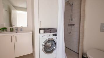 A modern bathroom with a Bosch washing machine, a shower, and a toilet.