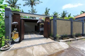 A gated entrance with a tiled pathway leading to a covered area. - Villa Twin Lovina (Banjar)