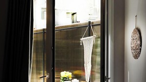 Une pièce dotée d’une porte-fenêtre coulissante donnant sur un espace extérieur aménagé avec une table et des chaises.