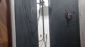 A bathroom with a shower, tiled walls, and a towel on the floor. - Big Boys' Bed & Burger (Patong)