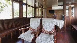 Un restaurant avec des bancs et des tables en bois, un mur en briques et un téléviseur fixé au-dessus du bar.