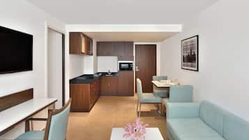 Een modern appartement met een zithoek, eethoek en keuken.
