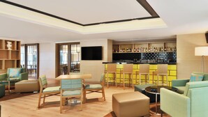 A modern living room with a bar area, including seating and a television. - Fairfield by Marriott Chennai OMR (Chennai)