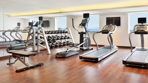 A gym with treadmills, elliptical machines, and free weights. - Fairfield by Marriott Chennai OMR (Chennai)