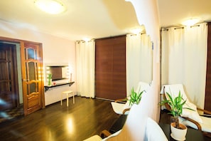 Relax in this serene room with a large window, two comfortable chairs, and a potted plant.
