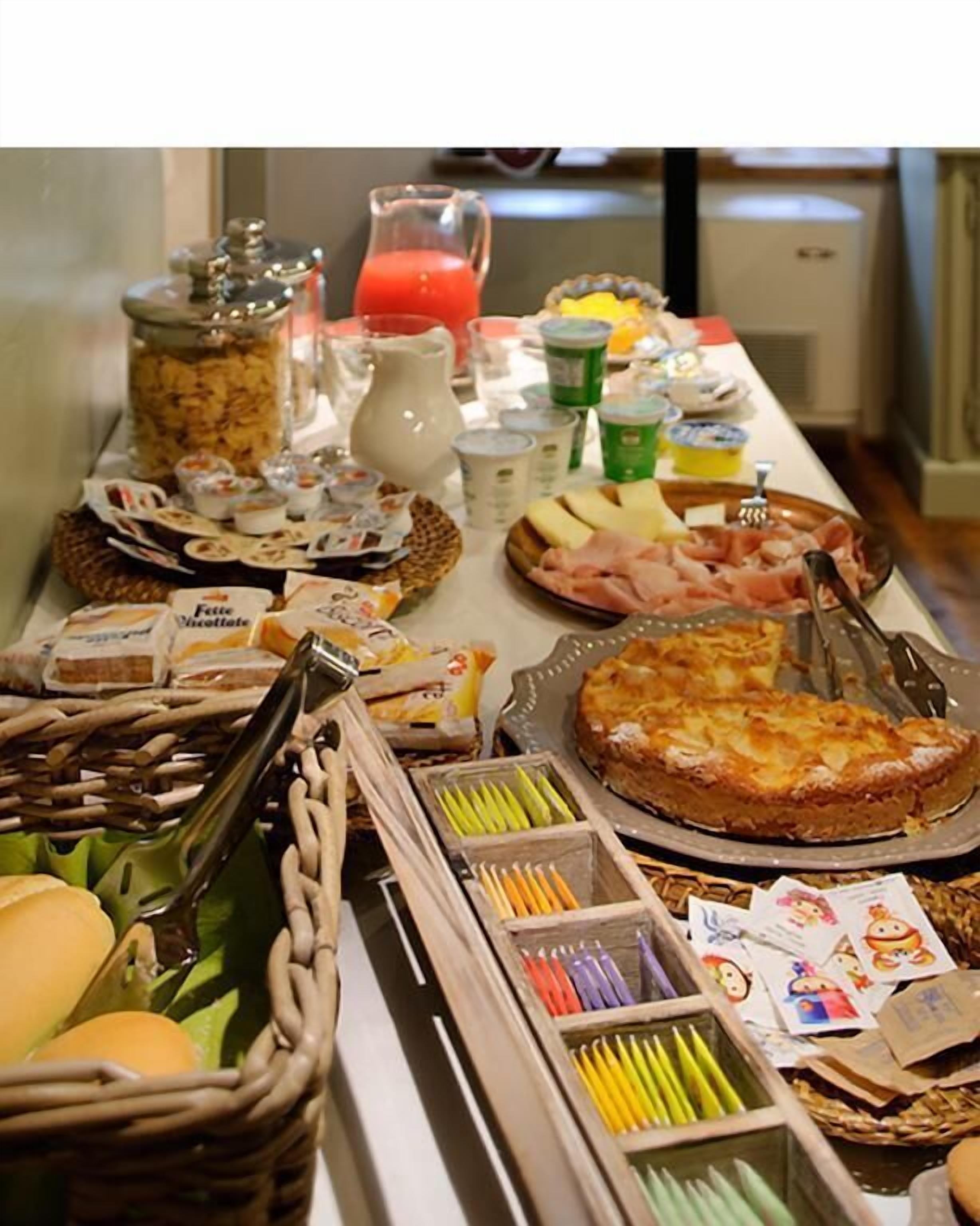 Un bufé con diversas opciones de comida, incluyendo pasteles, quesos y frutas.